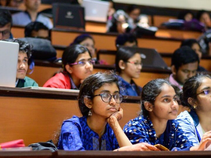 Students following a session in a full hall